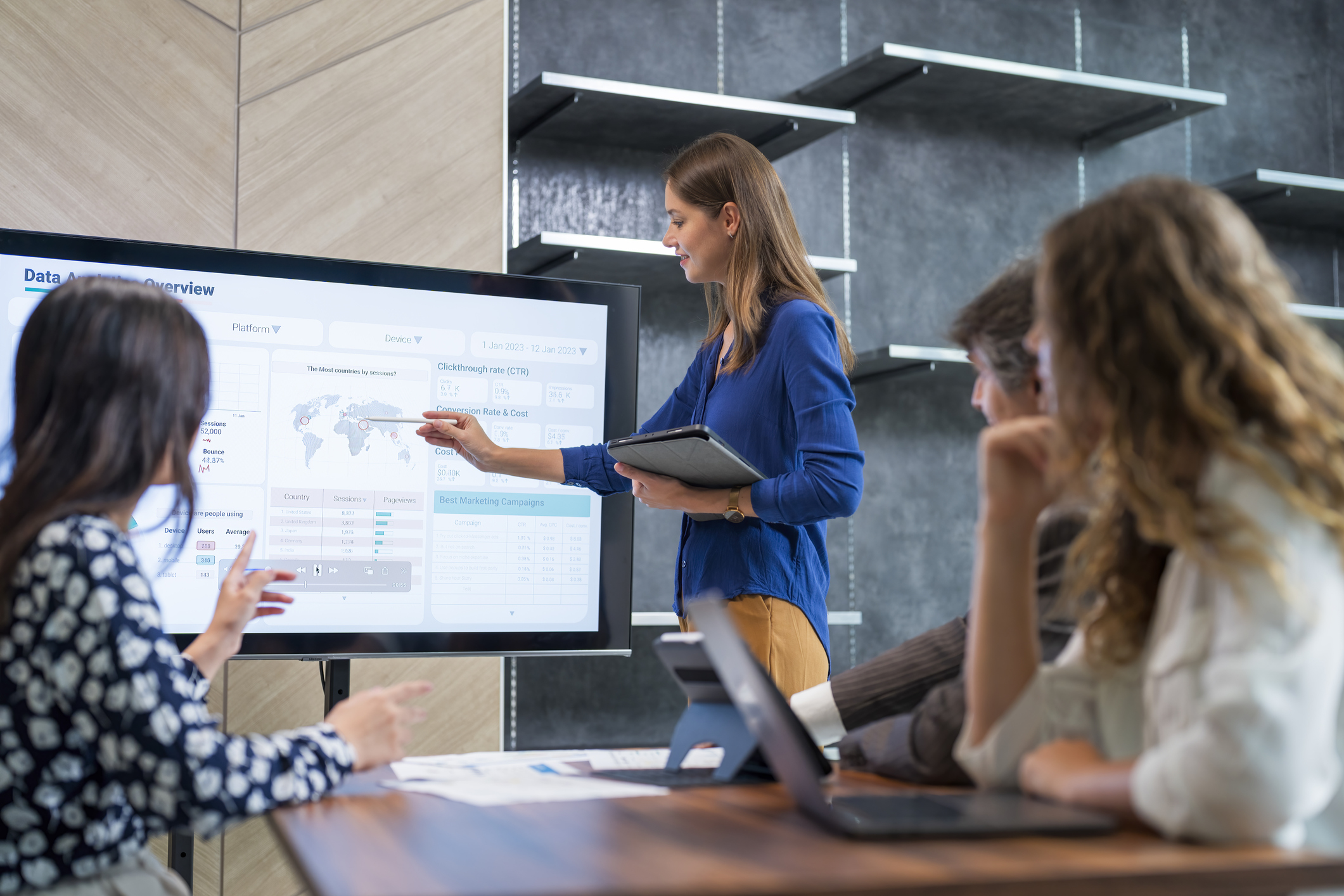 Businesswoman giving presentation to colleagues in meeting room.
